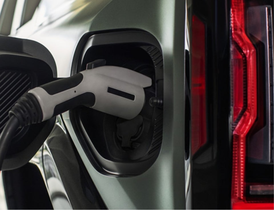 Close up of charging port with charger plugged in on a GMC Hummer EV SUV - Taylor Buick GMC in TAYLOR MI