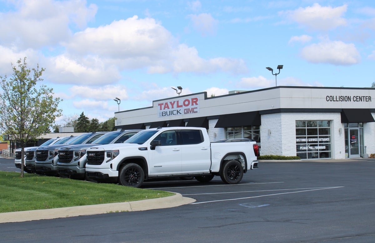 Exterior view of Taylor Buick GMC dealership with pickup trucks in the lote